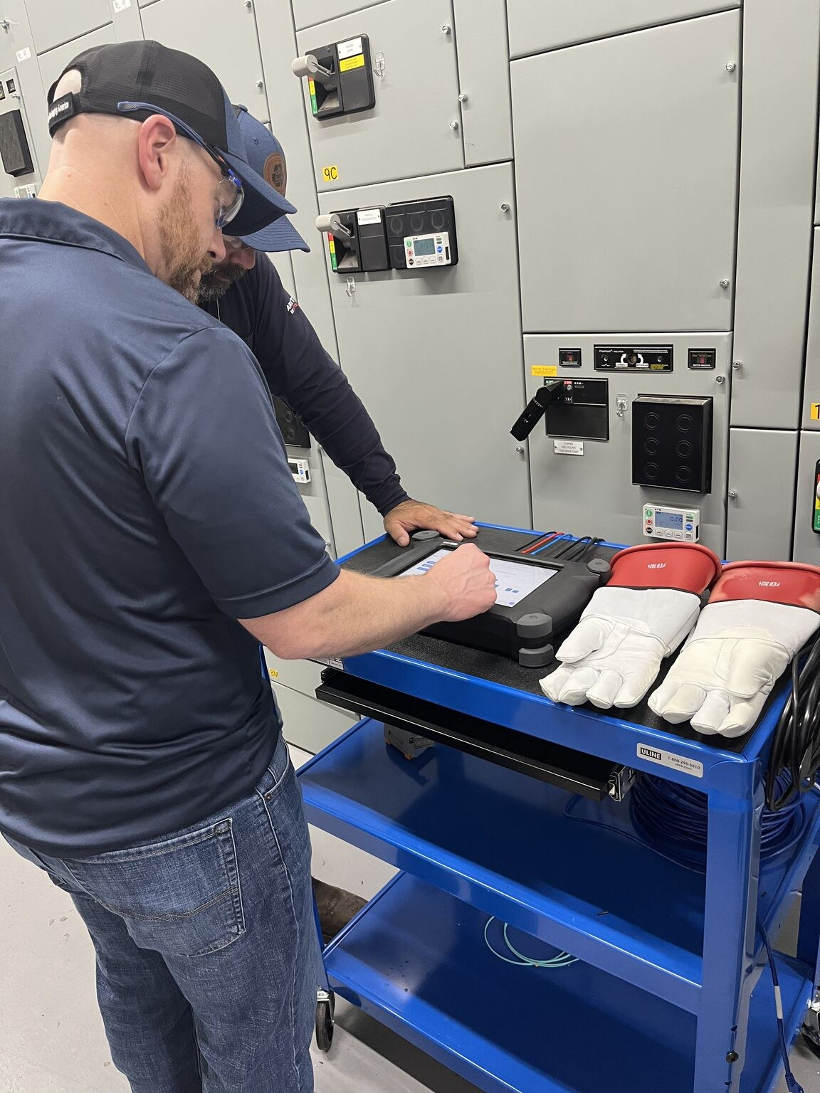 AMTPro - Test 13 Two engineers running an AMTPro test from a cart at the motor control center, with insulated gloves ready